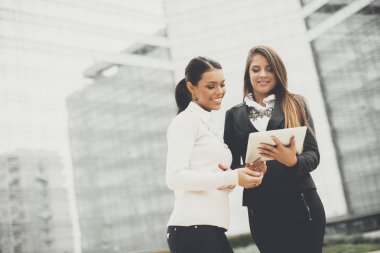 Genç iş kadınları ofis binası önünde