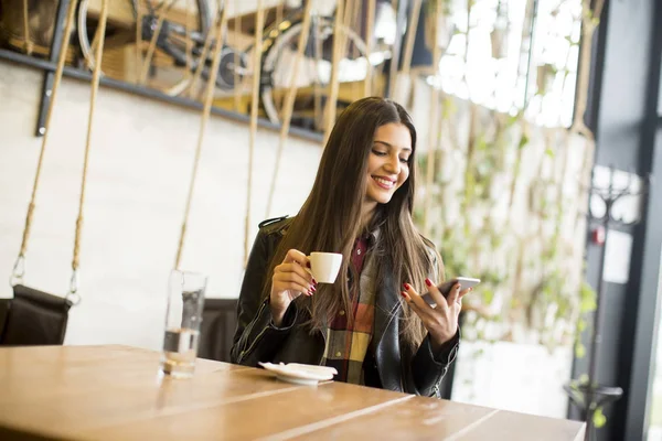 Женщина с телефоном в кафе — стоковое фото