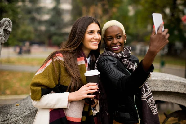 Multiracial young women with phone outdoor — Stock Photo, Image