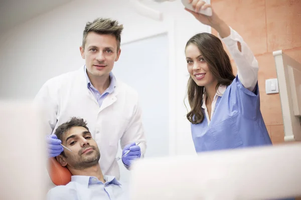 Jonge man met tandheelkundige chekup — Stockfoto