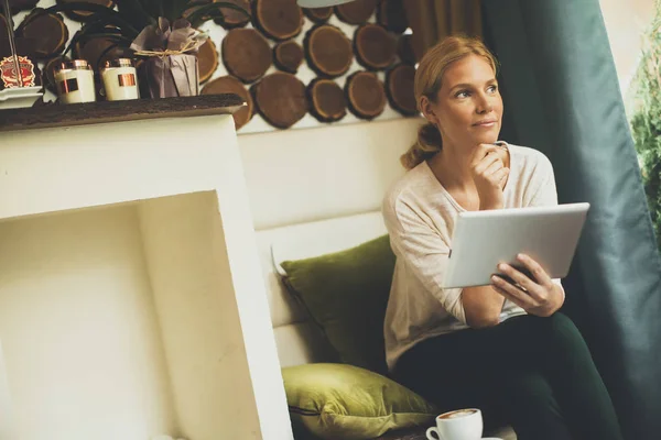 Kvinna sitter i café med tablett — Stockfoto