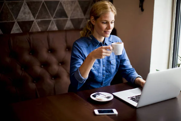 Hübsche junge Frau mit Laptop im Café — Stockfoto