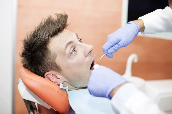 Joven asustado en el consultorio del dentista —  Fotos de Stock