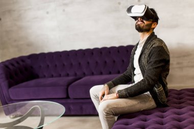 Adam sanal gerçeklik gözlüğü takıyor.