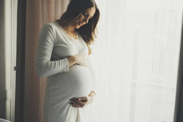 Mujer embarazada joven en el dormitorio — Foto de Stock