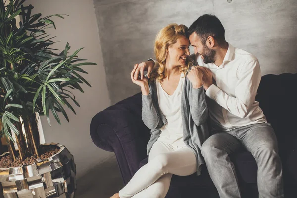 Paret sitter i soffan hemma — Stockfoto