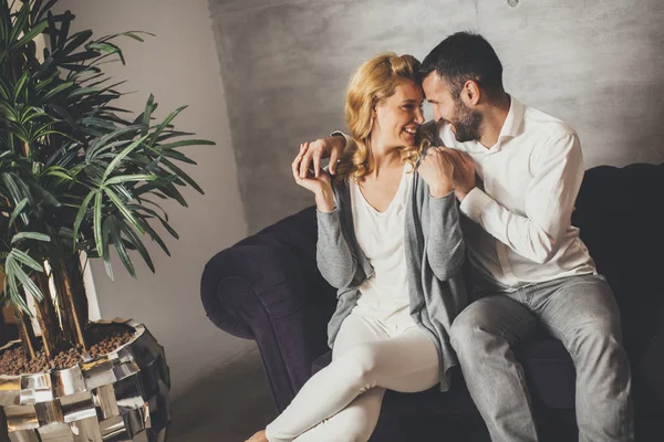 Casal sentado no sofá em casa — Fotografia de Stock