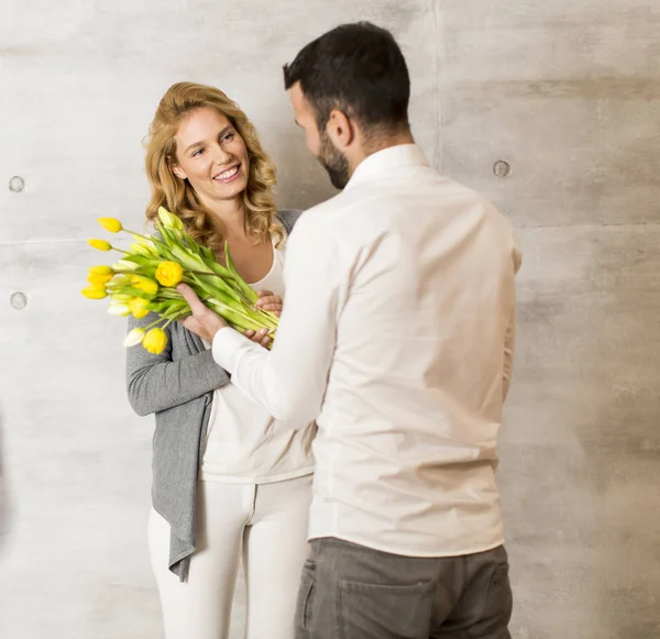 Hombre dando a chica un ramo de tulipanes — Foto de Stock