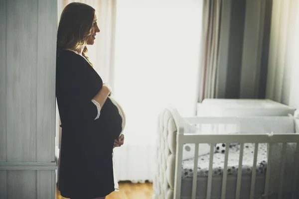 Mladá těhotná žena v ložnici — Stock fotografie