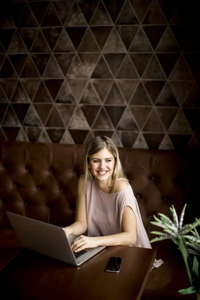 Junge freischaffende Frau mit Laptop — Stockfoto