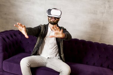 Adam sanal gerçeklik gözlüğü takıyor.