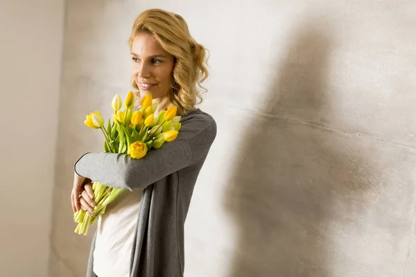 Mujer con tulipanes amarillos — Foto de Stock