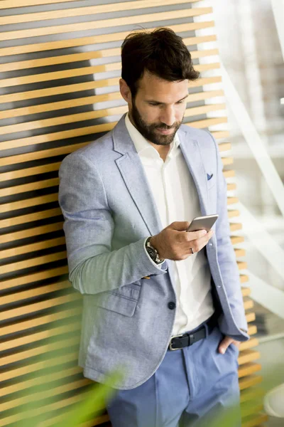 Homem de negócios moderno com telefone no escritório — Fotografia de Stock