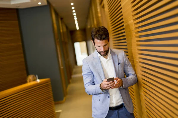 Homem de negócios moderno com telefone no escritório — Fotografia de Stock