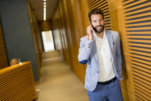 Modern businessman in office with phone — Stock Photo, Image