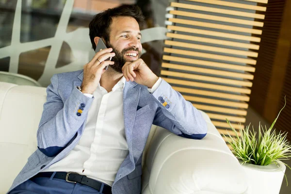 Современный бизнесмен в офисе с телефоном — стоковое фото