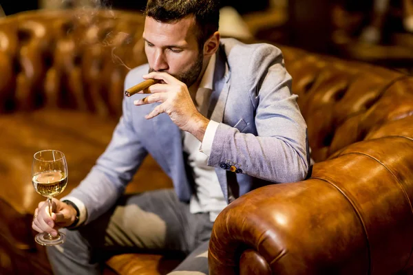 Man tasting wine and smoking cigar — Stock Photo, Image