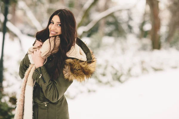 Женщина с меховым капюшоном в зимнем парке — стоковое фото