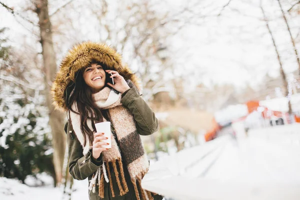 Mujer con teléfono en invierno —  Fotos de Stock