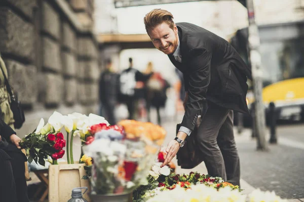 Mann kauft Blumen bei Straßenverkäufern — Stockfoto