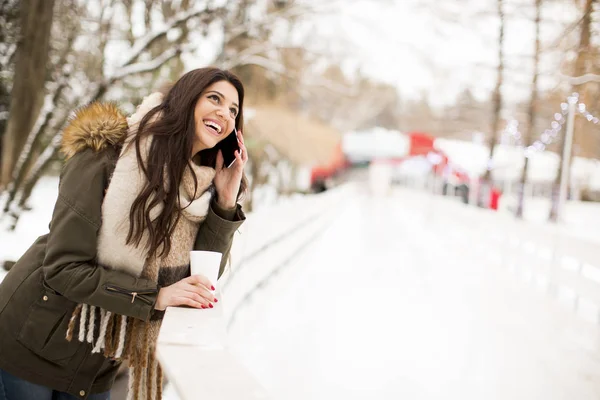 Женщина с телефоном зимой — стоковое фото