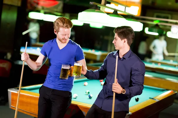 Men with beer playing billiards Stock Image