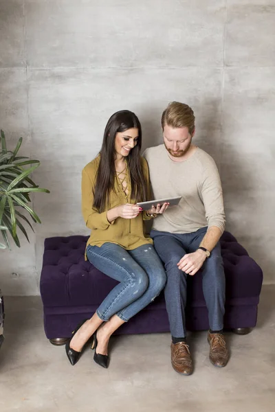 Пара сидить на дивані з планшетом — стокове фото