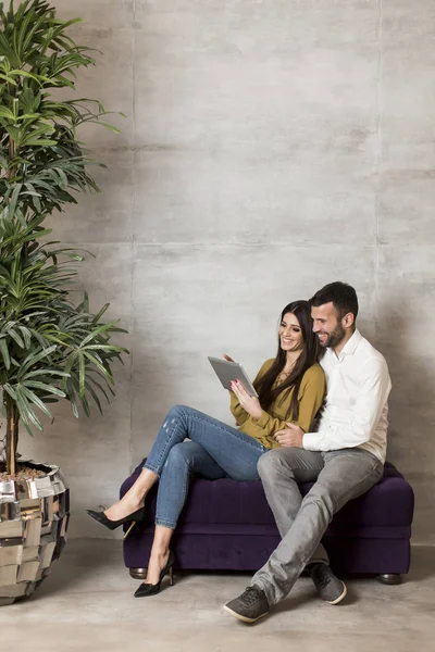 Paar zittend op de Bank met de Tablet PC — Stockfoto