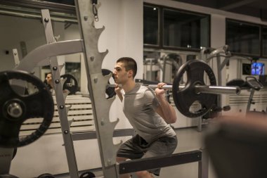 Spor salonunda ağırlık kaldırıyorum.