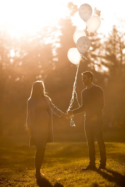 Loving para z balonów w parku — Zdjęcie stockowe