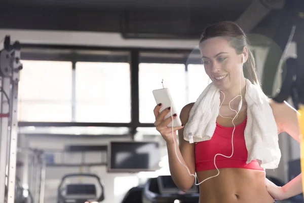 Donna che utilizza smartphone in palestra — Foto Stock