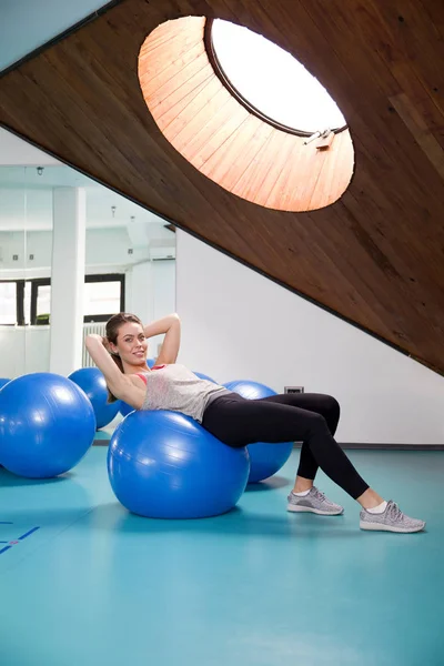 Mulher esportiva com uma bola de pilates — Fotografia de Stock