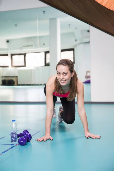 Woman exercises in fitness studio — Stock Photo, Image