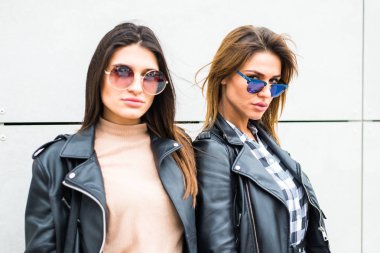 İki genç kadın güneş gözlüğü takıyor