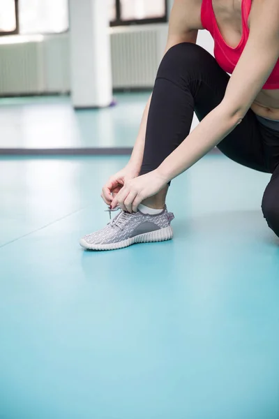 Mujer ata los cordones en los zapatos —  Fotos de Stock