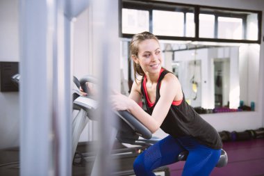 Spor salonunda egzersiz yapan bir kadın.