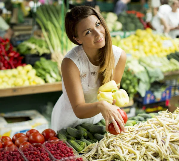 Kvinna köper grönsaker på marknaden — Stockfoto