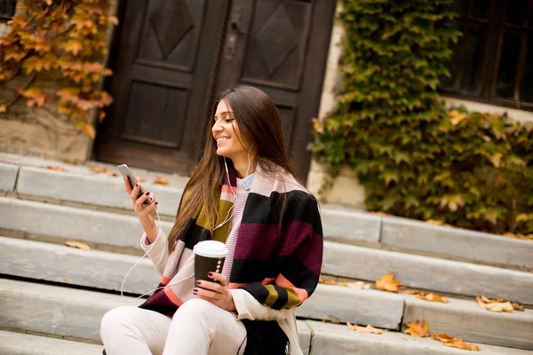 Mujer con teléfono y café al aire libre — Foto de Stock