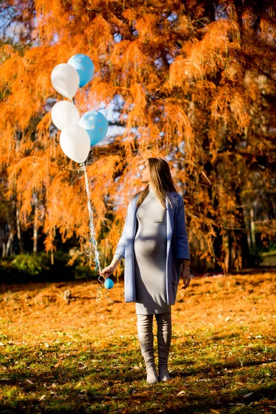 孕妇与气球在秋天的树林 — 图库照片