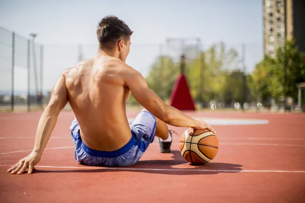 Человек отдыхает от игры в баскетбол — стоковое фото