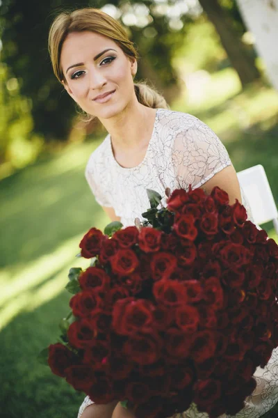 Giovane donna con rose rosse — Foto Stock