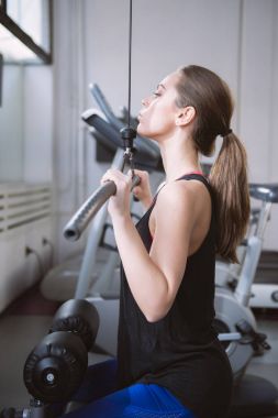 Kadın spor salonunda egzersiz yapıyor.