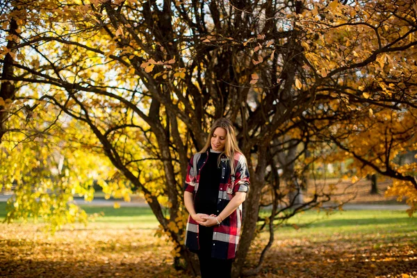 Gravid kvinna poserar i parken — Stockfoto