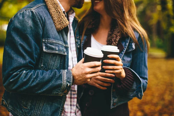 Coppia giovane nel parco autunnale con caffè — Foto Stock