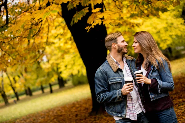 コーヒーと秋の公園で若いカップル — ストック写真