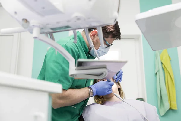 Стоматолог с пациентом в кабинете дантиста — стоковое фото
