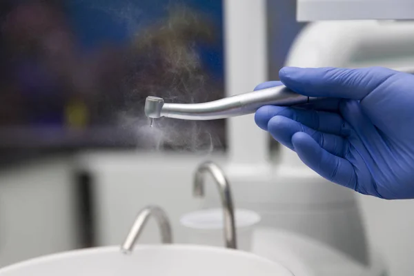 Шлифовальный станок для зубов в руке стоматолога — стоковое фото