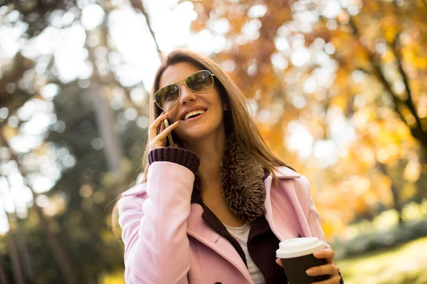 Donna nel parco autunnale con telefono — Foto Stock