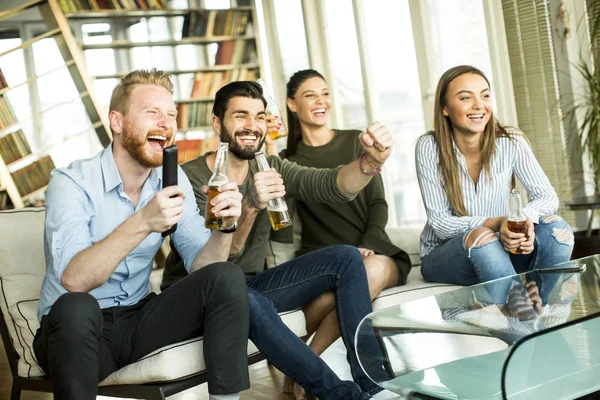 Groep jonge vrienden kijken naar de Tv, drinken van cider en hav — Stockfoto