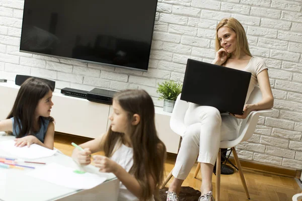 Little girls drawn in the room while mom talking on the phone an — Stock Photo, Image